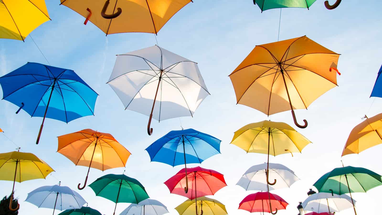 A graphic of umbrellas floating in the sky.