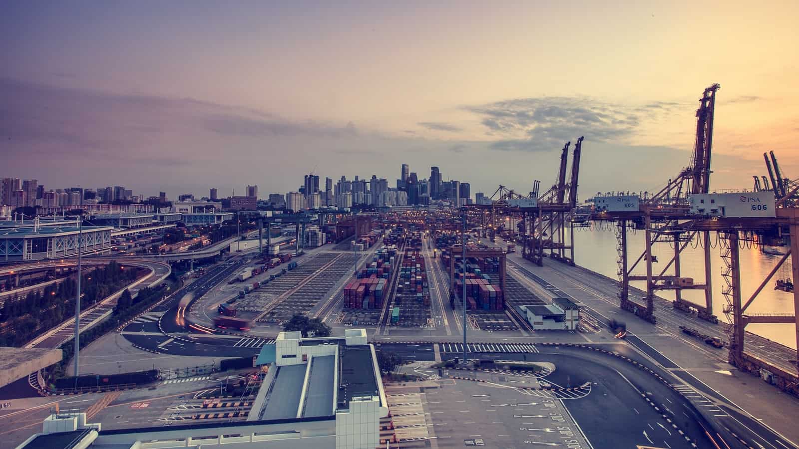 An aerial view of a port with cargo containers at sunset.