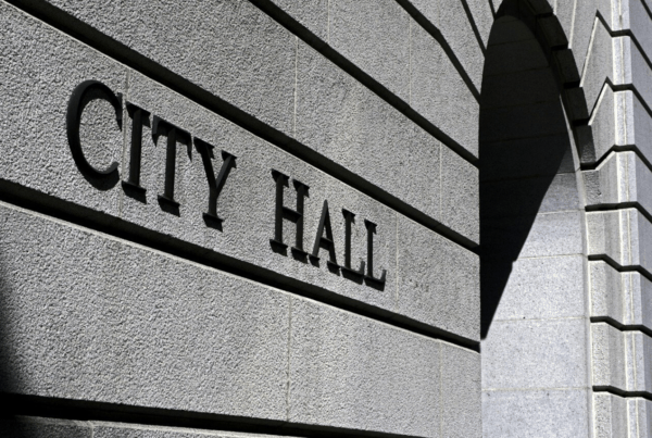A black and white photo of a building with the sign 'City Hall'.