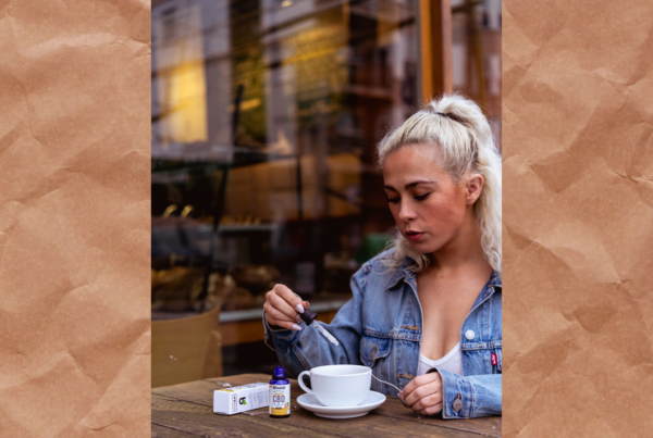 A photo of a woman dripping CBD oil into a coffee mug.