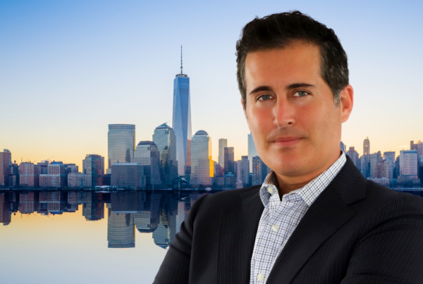 A photo of Michael Lieberman with a background of the NYC skyline at sunrise