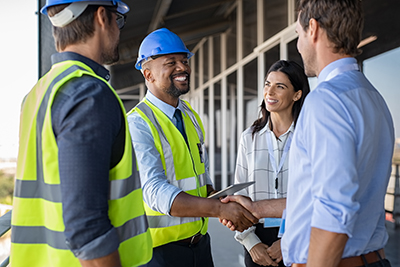 A photo of insurance professionals meeting with construction workers on a job site.
