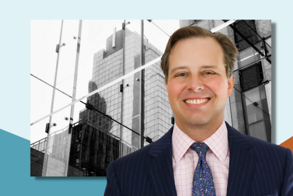 A photo of Justin Foa in front of a black & white photo of a NYC building.