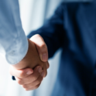 A photo of 2 professionals shaking hands.