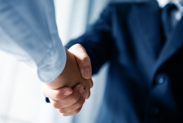 A photo of 2 professionals shaking hands.